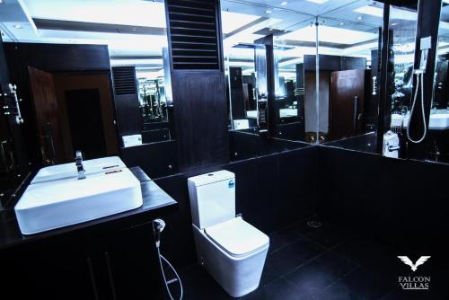 Un baño con un inodoro blanco y un lavabo. en Falcon Villas, en Lunugala