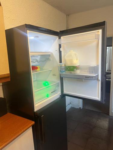 an empty refrigerator with its door open in a kitchen at Balfour House in Leicester