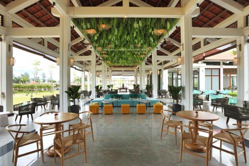 a restaurant with tables and chairs in a building at SBH Gloria Hue in Hue