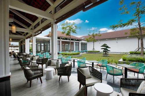 a patio with chairs and tables and a building at SBH Gloria Hue in Hue