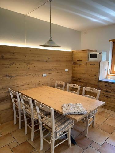 a wooden table and chairs in a kitchen at Villa la Dama del Lago in Molveno