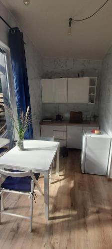 a kitchen with a white table and a refrigerator at OSADA POD LASEM in Andrychów