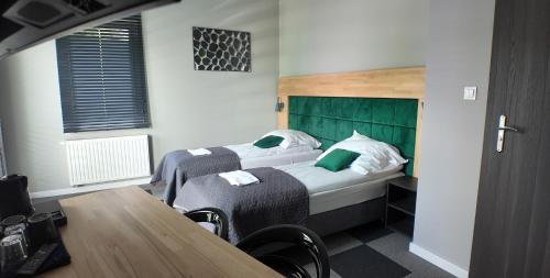 プワヴィにあるApartamenty Marciniakのベッド2台とテーブルがあるホテルの部屋
