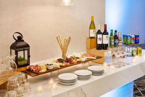a buffet with plates of food and bottles of wine at Sheraton Suites Chicago O'Hare in Rosemont