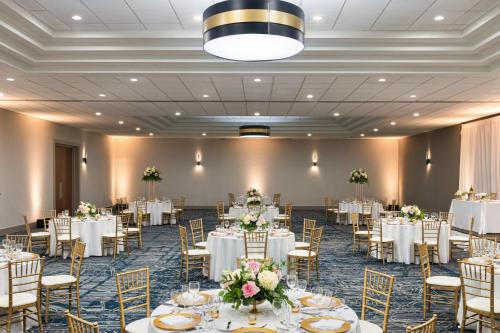 a banquet hall with white tables and chairs at Sheraton Suites Chicago O'Hare in Rosemont