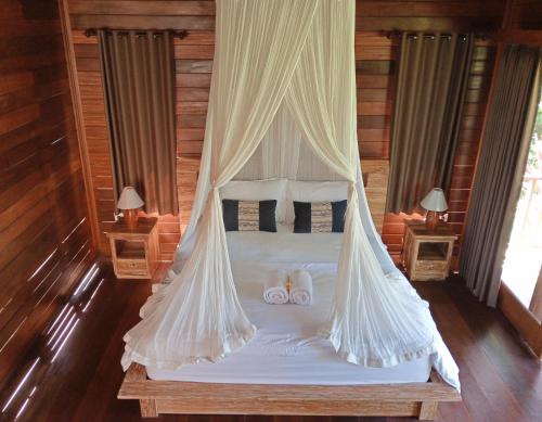 a bedroom with a bed with two slippers on it at Umedevasya in Sidemen