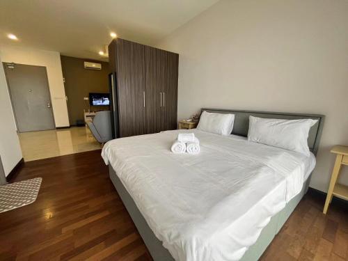 a bedroom with a large bed with two towels on it at Silverscape SeaView Residences Melaka in Malacca