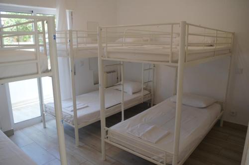 a room with three bunk beds and a window at Blife Faro Beach Hostel & Rooms in Faro