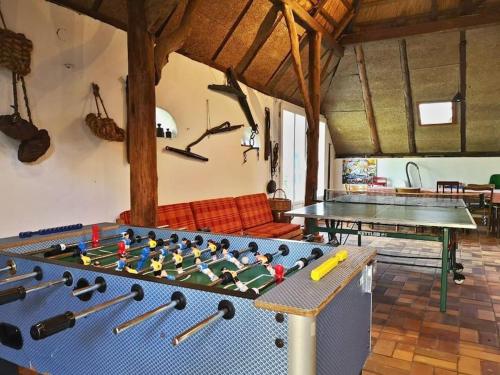 a living room with a large table with ping pong tables at Historisches Reetdach-Haus - bis zu 21 Personen in Großefehn 