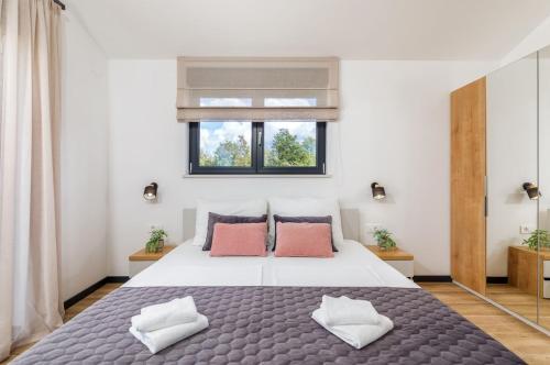 Un dormitorio con una cama grande con dos almohadas. en Villa Silvia by Villsy, en Nova Vas