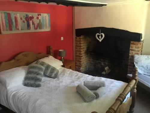 a bedroom with a bed with a brick fireplace at The Flying Horse Inn in Boughton Aulph