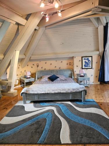 une chambre avec un grand lit avec un tapis dans l'établissement Le Berthoir, à Pélussin