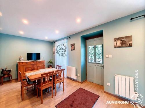 une salle à manger avec une table, des chaises et une télévision dans l'établissement Le Combolcha, à Murol