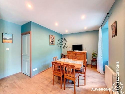 une salle à manger avec des murs bleus et une table et des chaises dans l'établissement Le Combolcha, à Murol