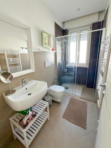 ein Badezimmer mit Waschbecken, Toilette und Dusche in der Unterkunft Flowing House in Brindisi