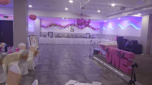 a large room with tables and chairs and purple lighting at Park Regis Lotus Hotel in Manama