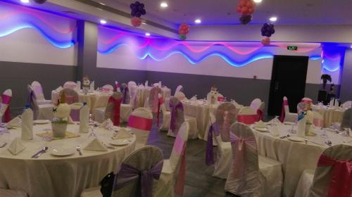 a group of tables with white table cloths in a room at Park Regis Lotus Hotel in Manama