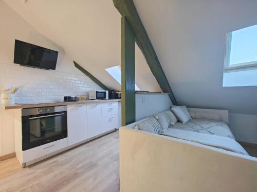 une cuisine avec un canapé et une télévision dans une pièce dans l'établissement Le Chistera, zen et intimiste, à Brive-la-Gaillarde