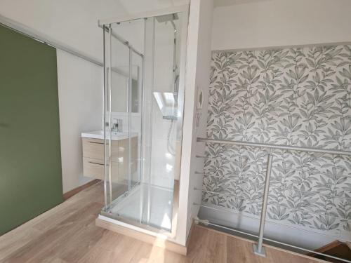 La salle de bains est pourvue d'une douche vitrée. dans l'établissement Le Chistera, zen et intimiste, à Brive-la-Gaillarde