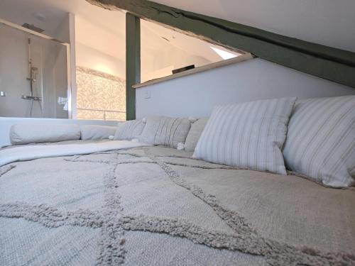 - un lit avec des oreillers blancs dans l'établissement Le Chistera, zen et intimiste, à Brive-la-Gaillarde