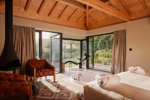 a bedroom with a bed and a chair and a tub at Dajas Douro Valley - Exclusive Villas in Sande