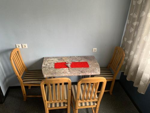 a table with two chairs and a table with a red box on it at Mõisavahe 30 two big beds 1 single bed in Tartu