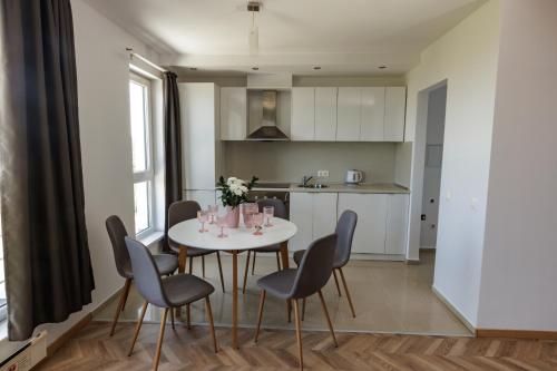 a kitchen and dining room with a white table and chairs at Saint George Palace Aparthotel in Bansko