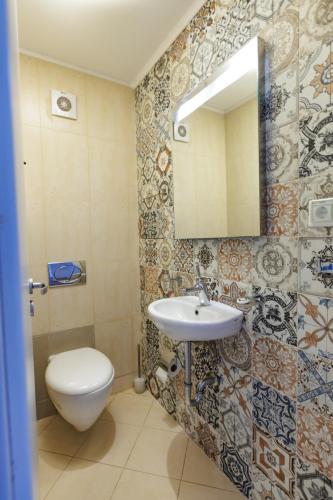 a bathroom with a toilet and a sink and a mirror at Saint George Palace Aparthotel in Bansko