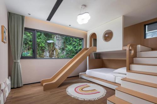 a childrens bedroom with a bunk bed and stairs at Dyed Mount Boutique Hotel in Yangshuo