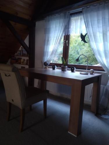 a wooden table with a chair in front of a window at 100 Stufen über dem Rhein in Oberwesel