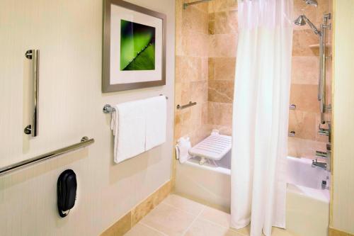 a bathroom with a tub and a shower with a shower curtain at Courtyard Cleveland University Circle in Cleveland