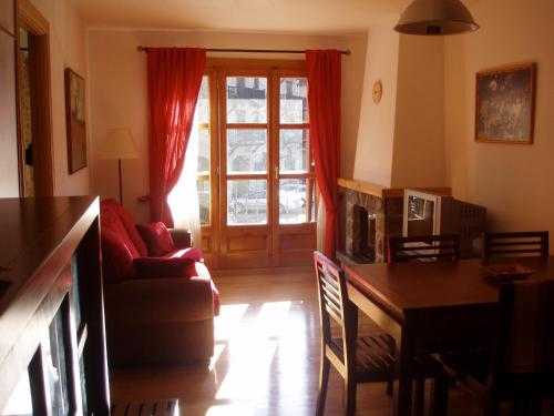 Una sala de estar con un sofá y una mesa y una puerta. en Apartamento Lamatriz Dequin Edificio Sayo 8, en Benasque