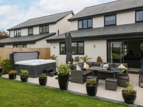 a backyard with a hot tub and patio furniture at Hedd in Amlwch