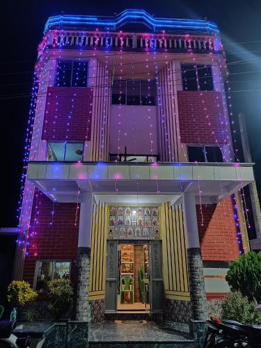 a building with purple and blue lights on it at Paribartan Hotel & Lodge in Farakka