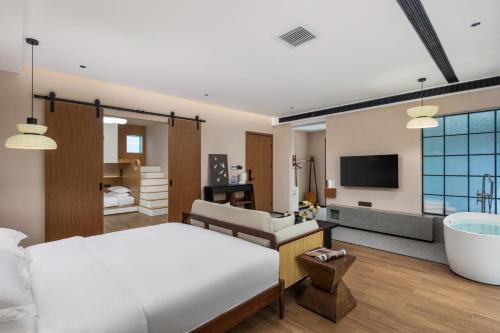 a bedroom with a large bed and a bath tub at Dyed Mount Boutique Hotel in Yangshuo