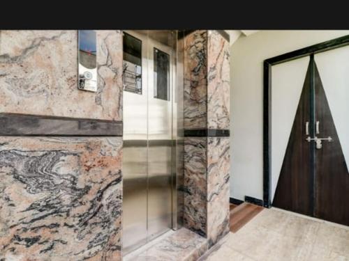 a glass door in a room with a stone wall at Sri sinampalli resedence in Visakhapatnam