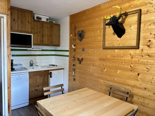 - une cuisine avec un mur en bois, une table et un évier dans l'établissement Enchanteur 2 pièces pour 4 pers. avec balcon, Alpe d'Huez - proche pistes et centre - FR-1-405-157, à L'Alpe-d'Huez