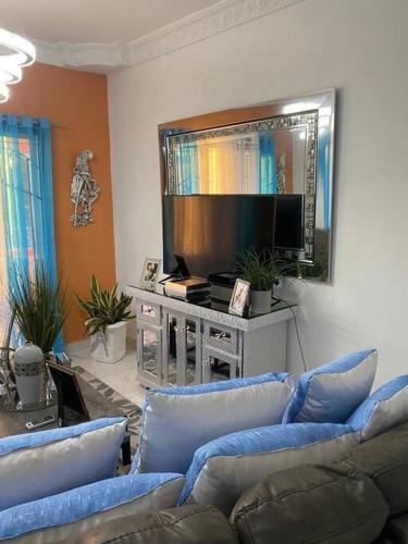 a living room with blue couches and a flat screen tv at Modern Country Side Lux Apt in La Ceibita