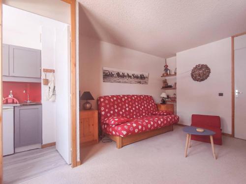 un salon avec un canapé rouge et une table dans l'établissement Grand studio divisible, pied des pistes à Valmorel, proche commerces - FR-1-356-408, à Valmorel