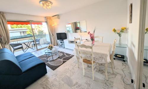 un salon avec une table et un canapé bleu dans l'établissement Ref FLEUR51 by Palmes dProperties, à Cannes