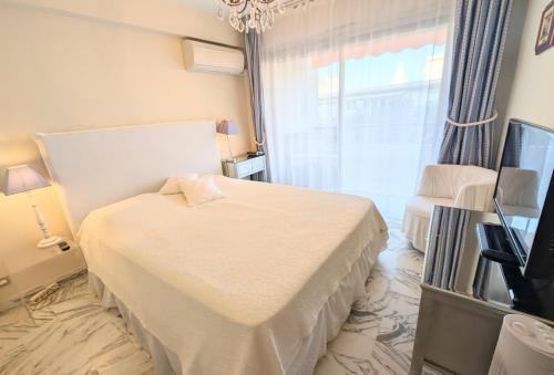 une chambre avec un lit, une télévision et une fenêtre dans l'établissement Ref FLEUR51 by Palmes dProperties, à Cannes