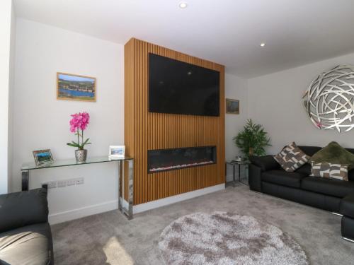 a living room with a tv and a fireplace at Hedd in Amlwch