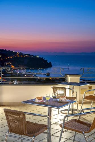 a table and chairs on a balcony with a view of the ocean at Hotel Bel Tramonto in Ischia