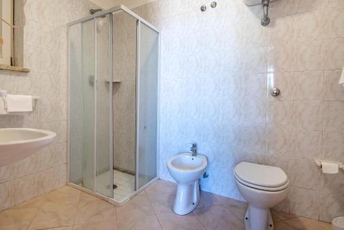 a bathroom with a shower and a toilet and a sink at Hotel Bel Tramonto in Ischia