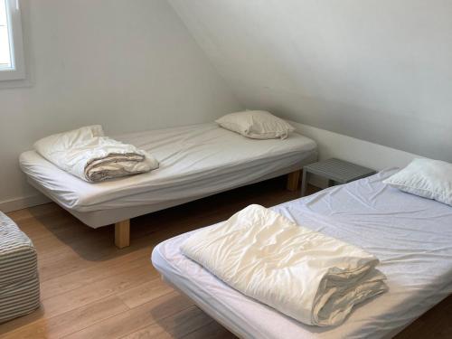 two beds in a small room with white sheets at Maison neuve moderne, proche plage Herlin, 5 chambres, jardin, terrasse, classement 3*, tout confort. - FR-1-418-194 in Bangor