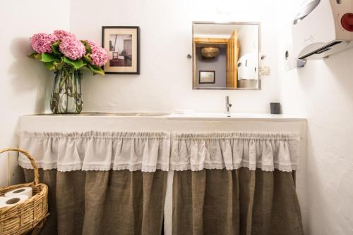 a bathroom with a sink and a vase of flowers at Casas de Juromenha in Juromenha