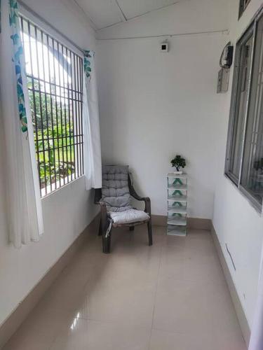 a empty room with a chair and a window at Greenwood Cabins Homestay, The Greenhouse in Jorhāt