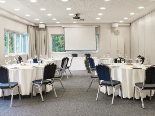 a conference room with tables and chairs and a whiteboard at Civitel Esprit in Athens