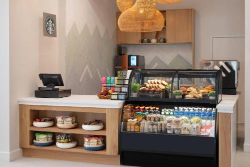a bakery with a counter with food and drinks at Delta Hotels by Marriott West Palm Beach in West Palm Beach