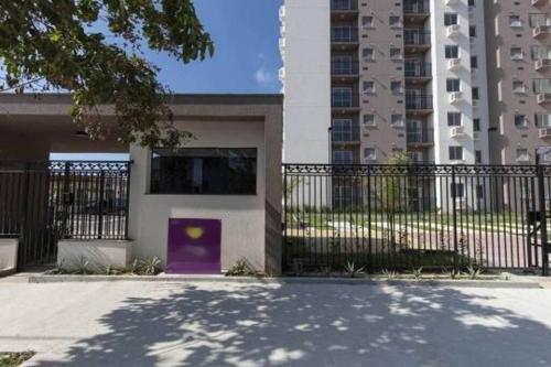 a building with a purple door in front of a fence at Conforto e paz de Ramos in Rio de Janeiro